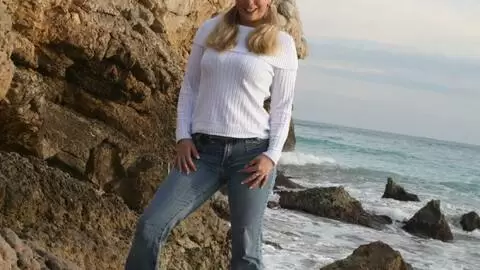 Pornostar young blonde with big boobs Calia B doing a strip by the sea 